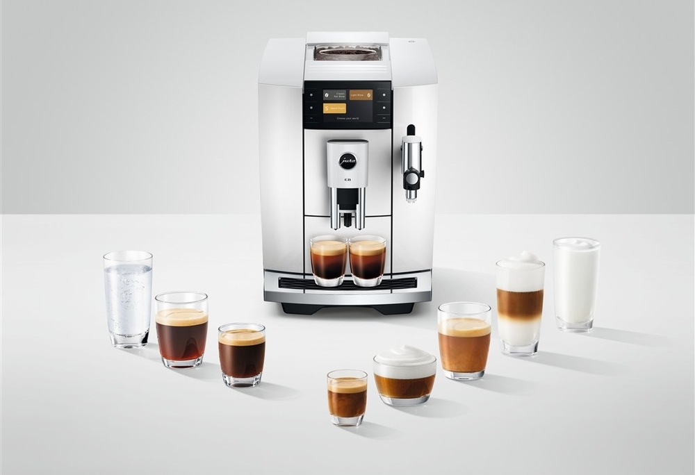 Automatický kávovar Jura E8 Piano White (modelový rok 2026) biely Automatický kávovar Jura E8 Piano White pripravuje dve šálky kávy zároveň, okolo kávovaru je rozostavaných osem pohárov s rôznymi druhmi kávy