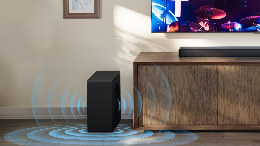 Soundbar Hisense AX3120Q čierny Výkonný subwoofer vedľa televízneho stolíka zaisťuje hlboké basy v modernom domácom kine.