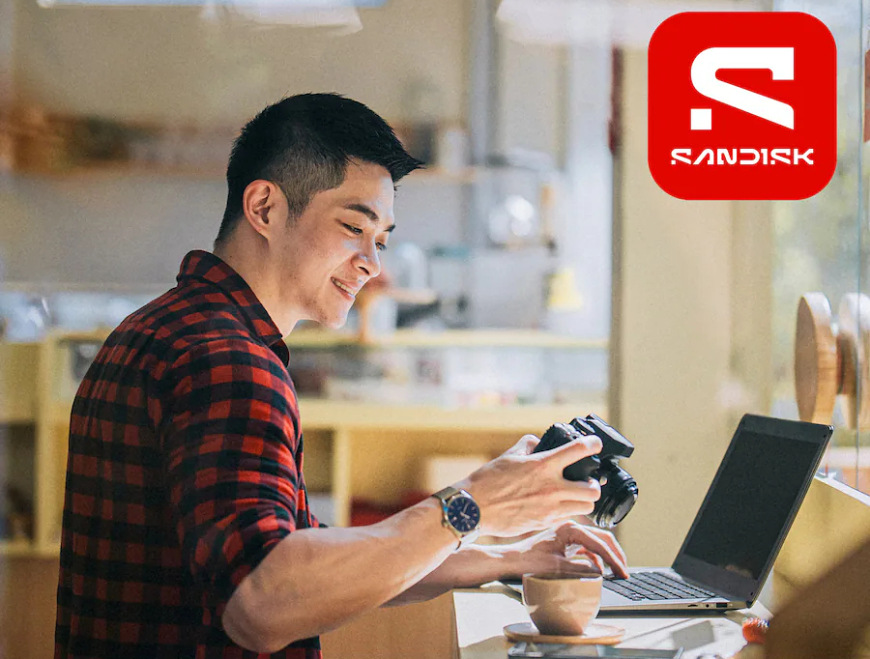 Fotograf prenáša snímky z fotoaparátu do notebooku pomocou pamäťovej karty SanDisk Ultra Plus