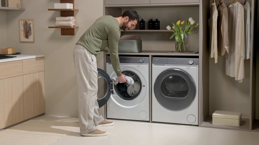 Práčka Haier HW80-B14367U-S biela muž v práčovni dáva do práčky haier HW80-B14367U-S bielizeň