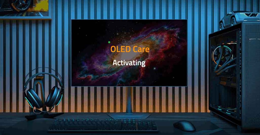Herný monitor GIGABYTE MO27Q28G čierny Slabo osvetlená miestnosť s počítačom. Na obrazovke sa na kozmickom pozadí zobrazuje nápis „Funkcia OLED Care aktivovaná“. Slúchadlá a herná veža vyžarujú jemné modré svetlo.
