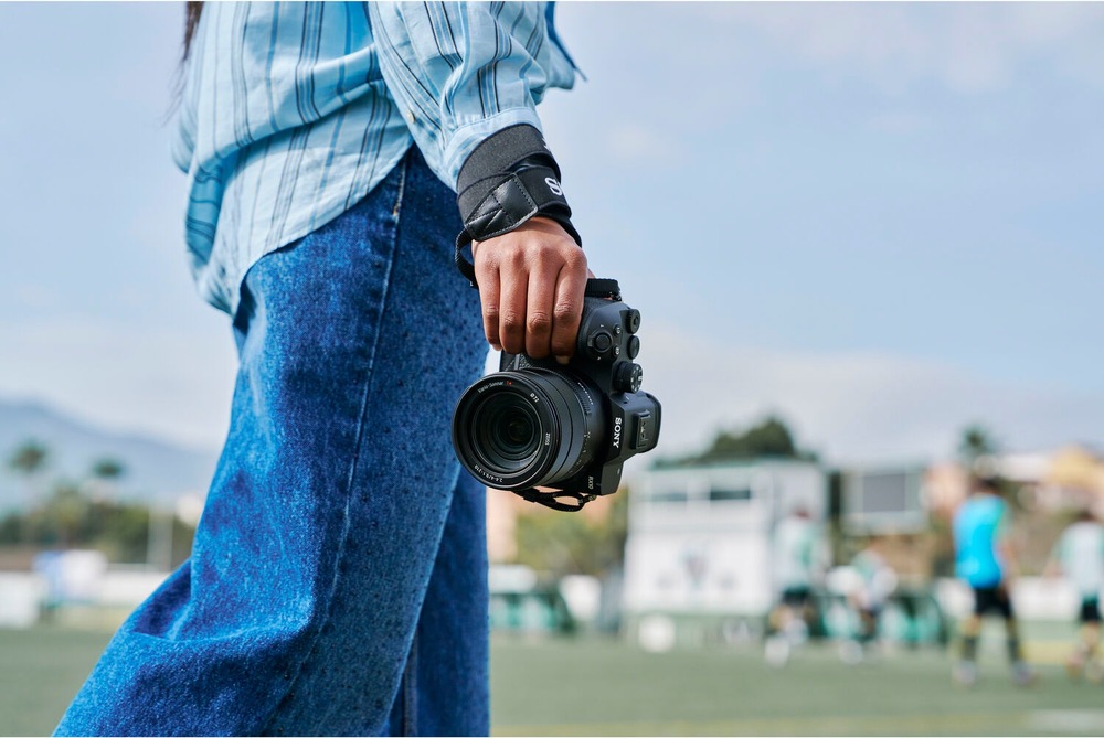 Fotografka drží kompaktný fotoaparát Sony RX10 V pripravený na fotografovanie športových akcií