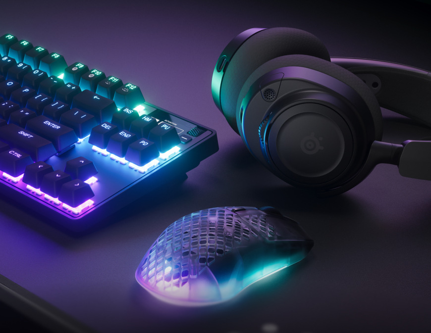 Myš SteelSeries Aerox 3 Wireless Gen 2 - Shadow čierna Myš SteelSeries pri podsvietenej klávesnici a headsete