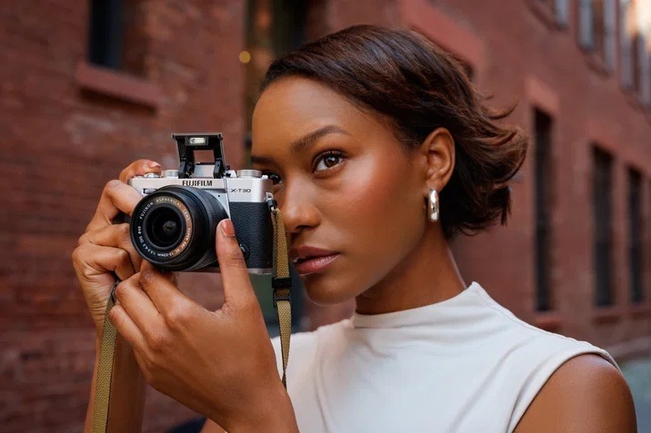 Digitálny fotoaparát Fujifilm X-T30 III, telo čierny/sivý Žena fotografujúca pomocou fotoaparátu Fujifilm X-T30 III s automatickým bleskom