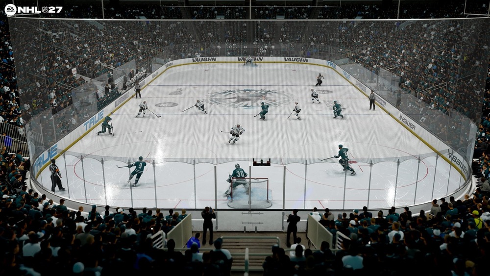 Hokejový zápas v NHL 27 v zaplnenej aréne, kde tímy v tyrkysovo bielych dresoch bojujú blízko gólu, zatiaľ čo brankár stráži sieť.
