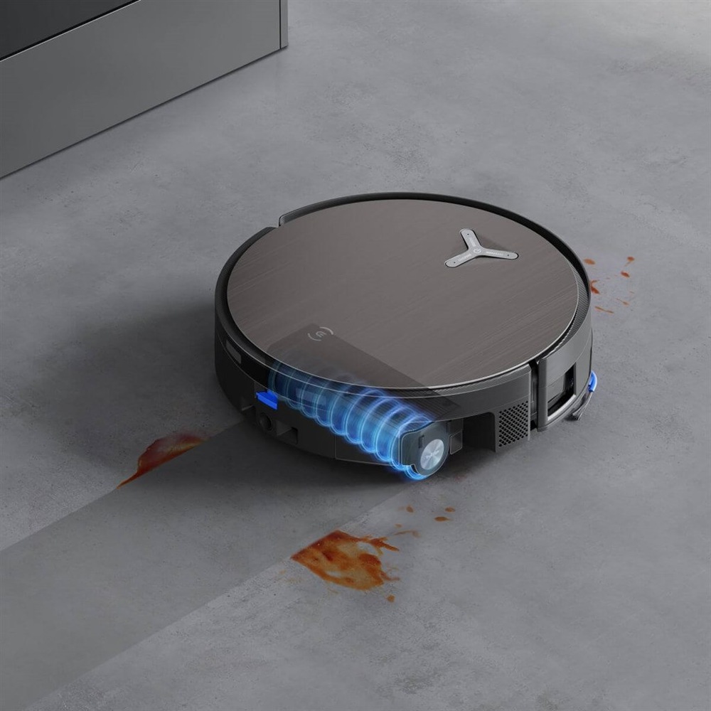 Robotický vysávač Ecovacs DEEBOT X11 OMNICYCLONE SILVER strieborný Robotický vysávač Ecovacs DEEBOT X11 OMNICYCLONE SILVER prechádza cez škvrnu na podlahe, miesto, kadiaľ vysávač prešiel, je čisté. Umývací valec vysávača je modro zvýraznený.