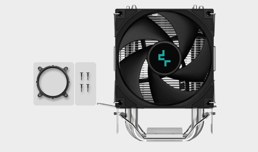 Vidíme čierny chladič CPU s veľkým ventilátorom a kovovými tepelnými trubicami. Vľavo je na svetlo šedom pozadí montážny krúžok a štyri pripevňovacie štipce.