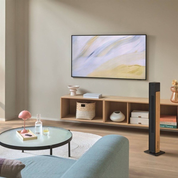 Vežový ventilátor Stadler Form Nick Bamboo Black v obývacej izbe pri TV stene.