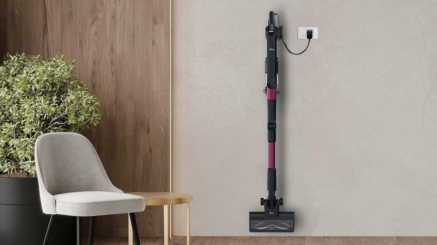 Tyčový vysávač Hoover HF210HXP 011 visí na nástennom držiaku a nabíja sa