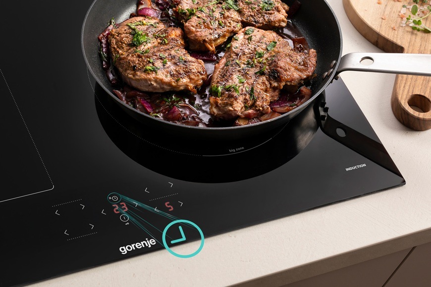 Na indukčnej varnej doske Gorenje GI6431BFG sa na panvici pripravuje mäso s presným dotykovým ovládaním výkonu.