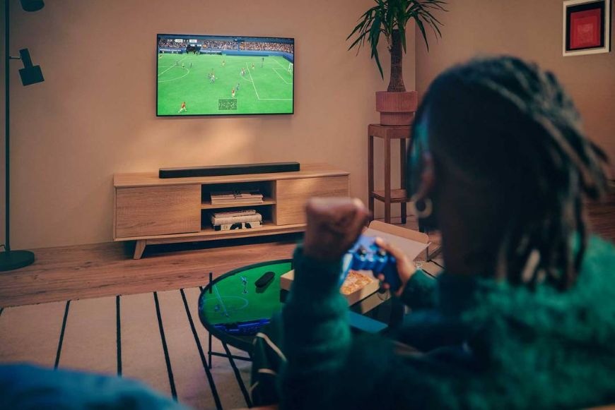 Soundbar JBL BAR 300 MK2 čierny Muž hrá hru na televízii so zvukom zo soundbaru JBL BAR 300 MK2