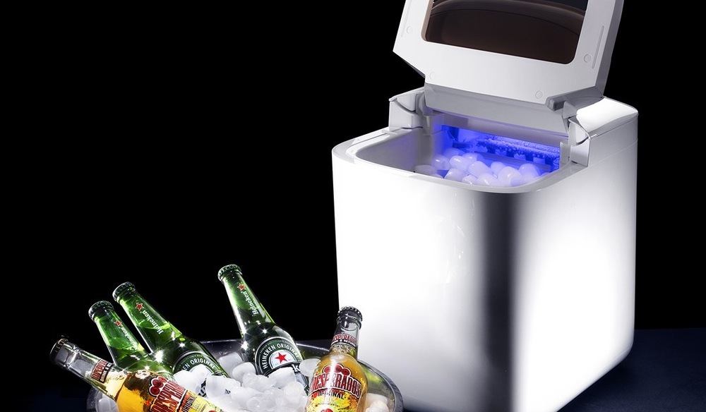 Výrobník ľadu Catler IM 810 Ice Maker biely Otvorený výrobník ľadu Catler IM 810 Ice Maker, v zásobníku je ľad, pred výrobníkom leží nádoba s chladenými fľašami piva