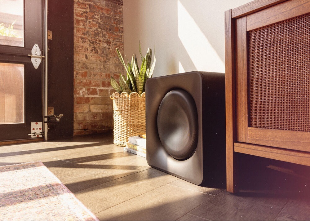 Subwoofer Klipsch Flexus SUB 200 čierny Subwoofer Klipsch Flexus SUB 200 stojí na zemi vedľa skrinky v obývacej izbe