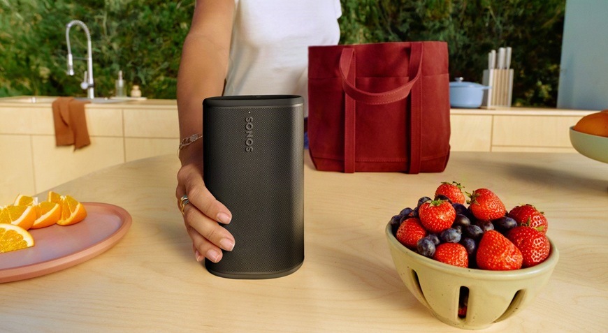 Prenosný reproduktor SONOS Play biely Žena pokladá reproduktor na kuchynskú linku.