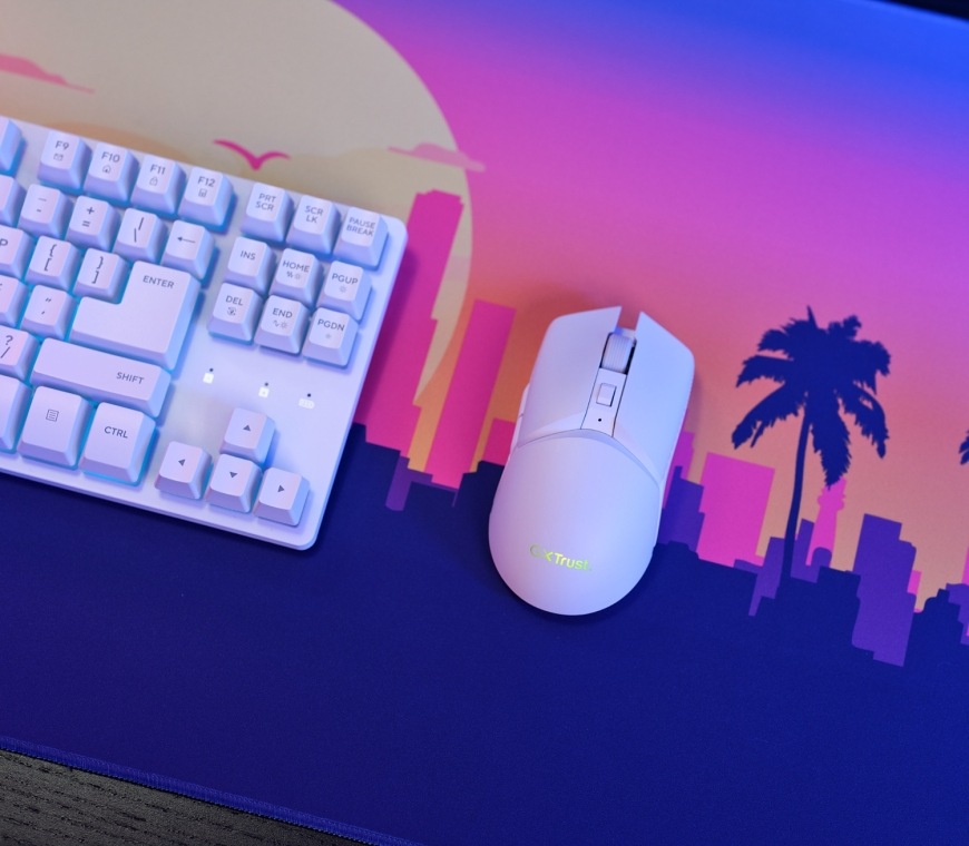 Klávesnica s myšou Trust GXT 882 Wireless - TKL Keyboard, Mouse & XXL Mousepad Miami - CZ/SK biela farba Myš Trust GXT 882 Miami vedľa podsvietenej klávesnice na podložke s palmami