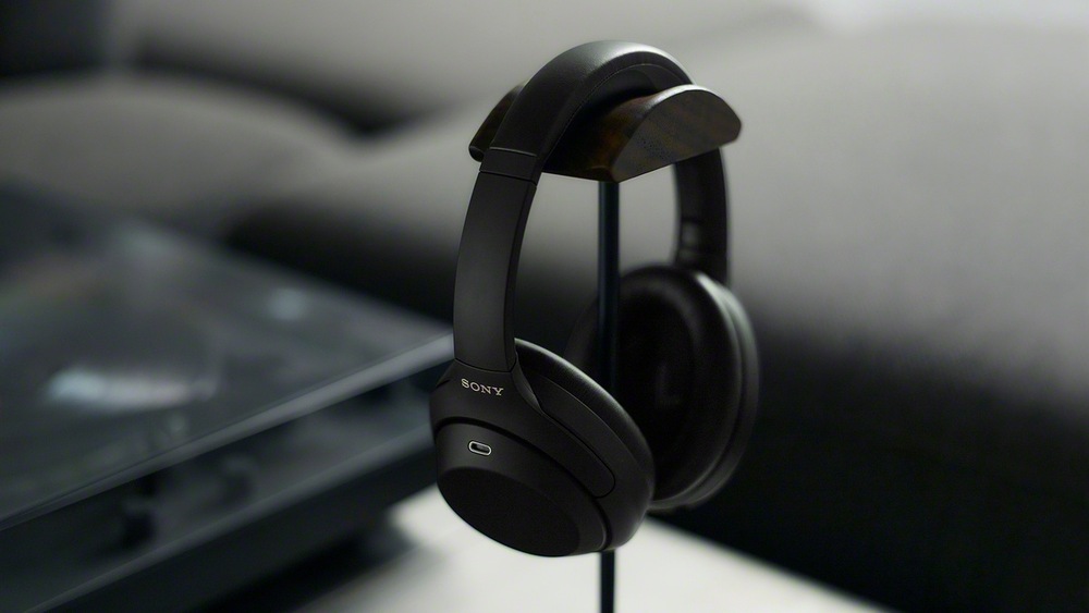 Slúchadlá Sony WH-1000XM4C čierna Sony WH-1000XM4C zavesená o nábytok