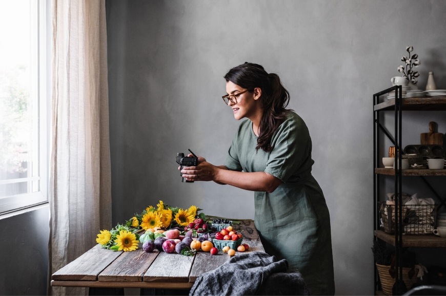 Digitálny fotoaparát Nikon Z 5II + 24-105 mm f/4-7.1 čierny Žena zachytávajúca zátišie pomocou fotoaparátu Nikon Z 5II s polohovateľným displejom