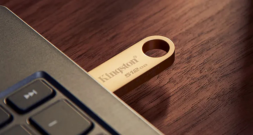 USB flashdisk Kingston DataTraveler SE9 G3 64GB zlatý USB flashdisk Kingston DataTraveler SE9 G3 zasunutý do USB portu notebooku, so zameraním na kompaktné rozmery a nízky profil pri pripojení
