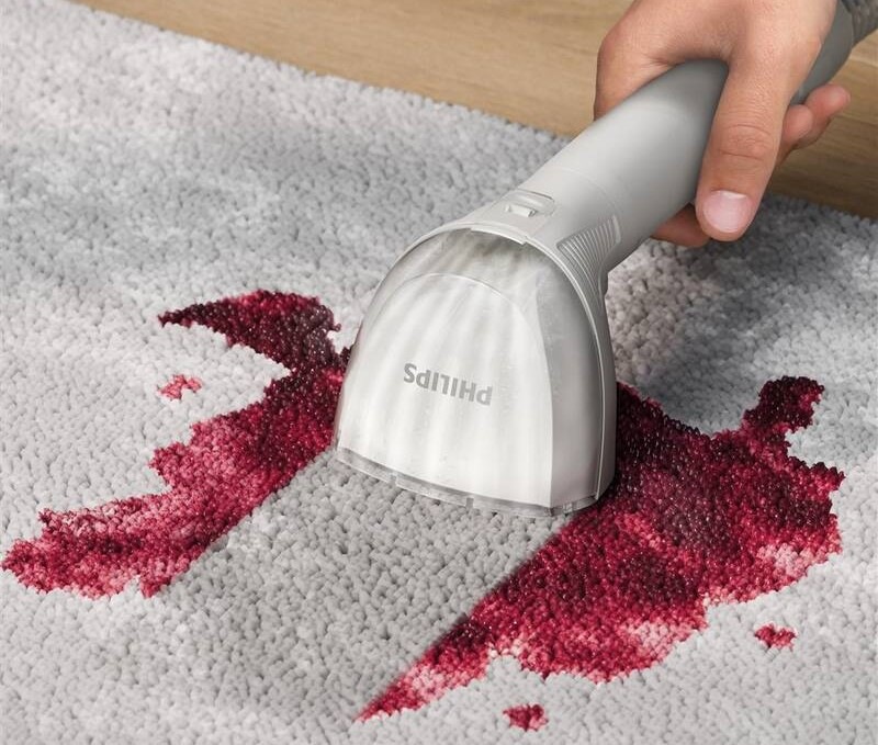 čistič škvŕn Philips 3000 Series XW3193/11 v akcii - práve z koberca odstraňuje červenú rozliatu tekutinu