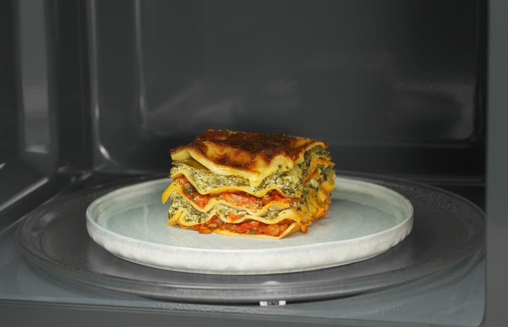 Kúsok lasagny na tanieri v mikrovlnnej rúre Electrolux.
