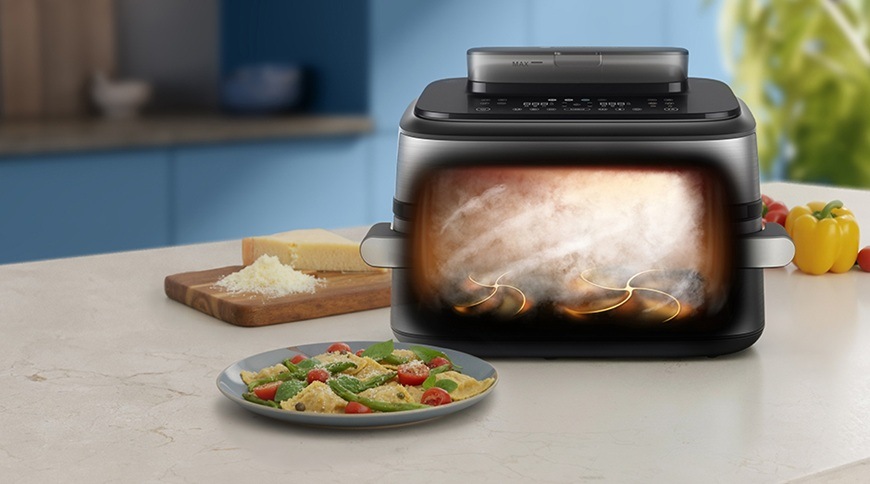 Fritéza teplovzdušná Philips Airfryer Dual Basket s párou 9,5 l NA565/02 čierna/strieborná Teplovzdušná fritéza Philips NA565/02 s grafickým znázornením prúdenia horúceho vzduchu a pary vo vnútri počas prípravy jedla. Na kuchynskej linke vedľa spotrebiča je tanier s cestovinami, doštička so syrom a čerstvá zelenina.