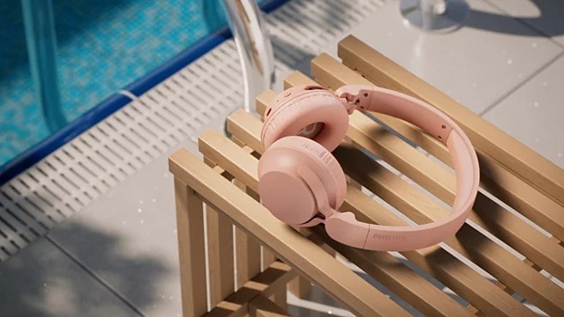 Slúchadlá Philips TAH4500 položené na lavičke vedľa bazéna
