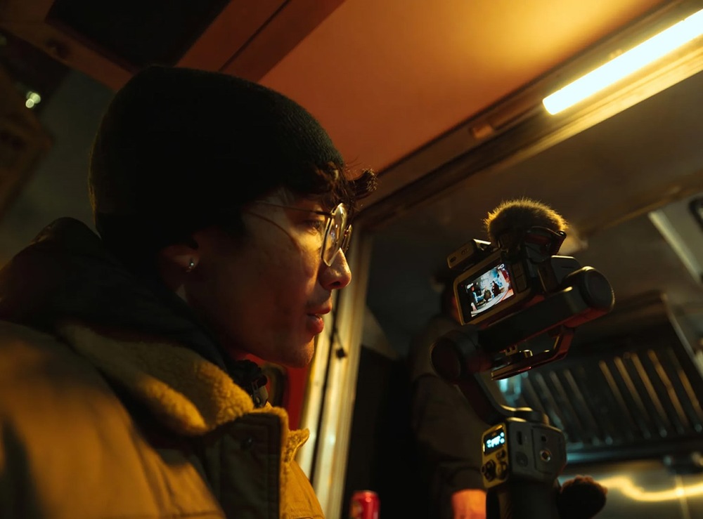 Outdoorová kamera GoPro MISSION 1 PRO Ultimate Creator Edition čierna Kameraman počas večerného natáčania sleduje záber na displeji kamery GoPro