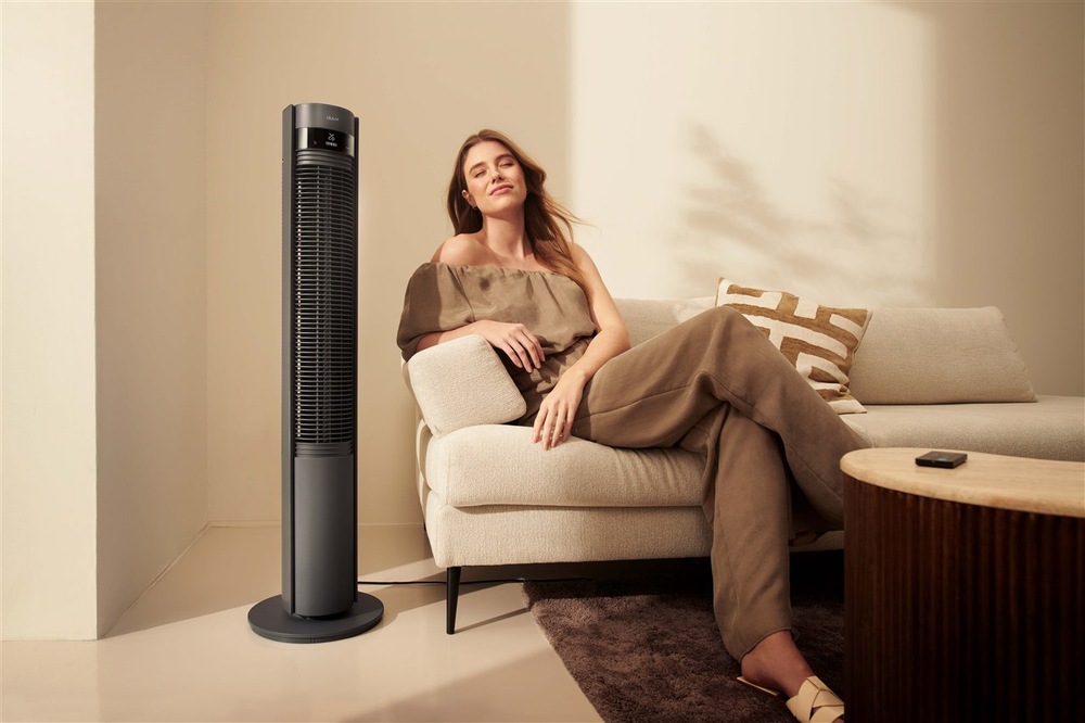 Ventilátor stĺpový Duux DXTF10 Elevate Smart Gray sivý dizajnový ventilátor Duux Elevate Tower Smart v interiéri vedľa pohovky