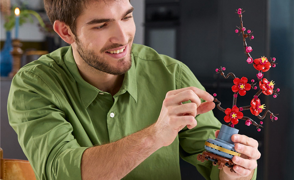 Stavebnica LEGO® Botanicals 10369 Meruňka japonská Pastelovo modrý kvetináč so zlatým pásikom a dreveným podstavcom vytvára pôsobivé dekoratívne aranžmány.