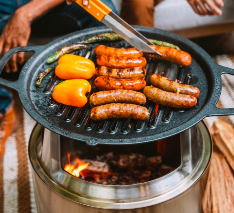 Grilovací rošt Solo Stove Bonfire Liatinový grilovací rošt Solo Stove Bonfire s klobásami a zeleninou pripravovanými nad ohniskom