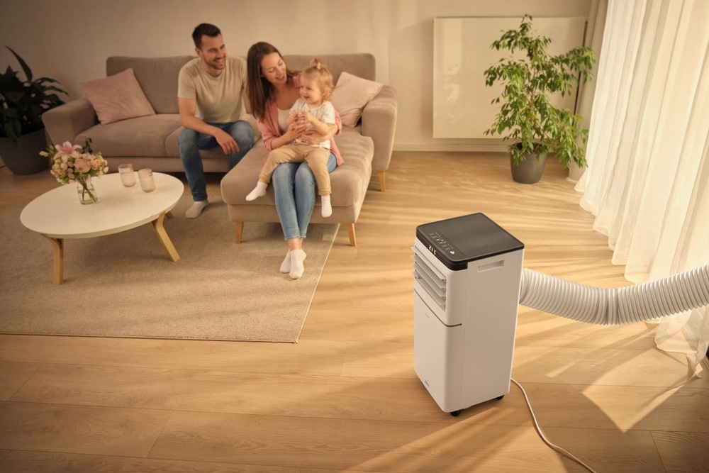 Mobilná klimatizácia Sencor SAC MT1042C Wi-Fi, 10 000 BTU/h biela Mobilná klimatizácia Sencor v obývacej izbe a mladá rodina sediaca na sedacej súprave
