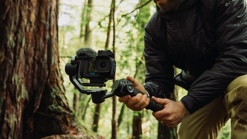 Mikrofón GoPro Media Mod MISSION 1 čierne Muž natáčajúci kamerou GoPro na stabilizátore v lese