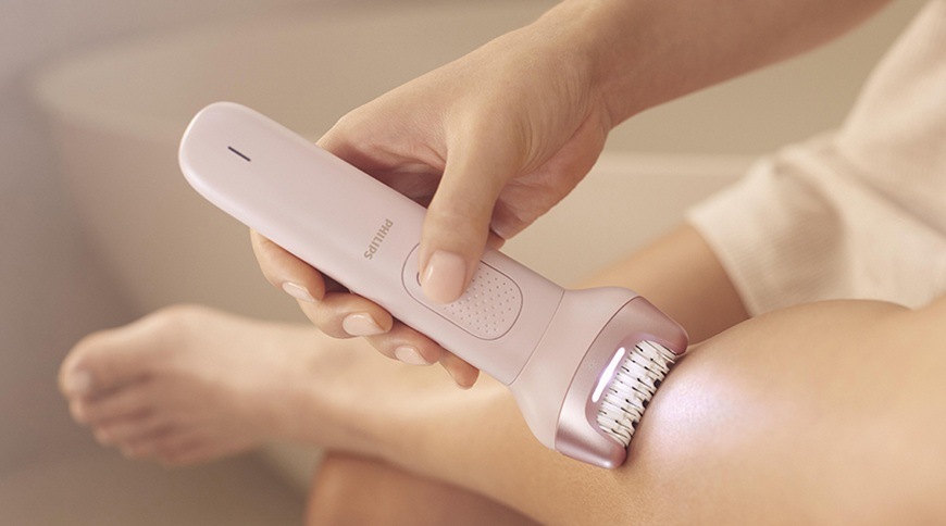 Epilátor Philips BRE718/00 ružový Detail použitia epilátora Philips BRE718/00 v ružovej farbe na pokožke nohy, epilačná hlavica s osvetlením je priložená k ošetrovanej oblasti.