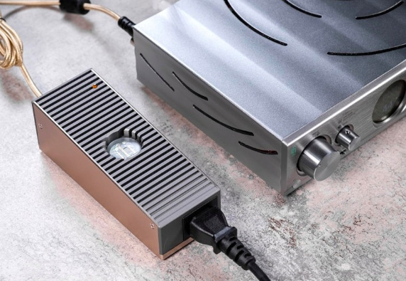 Sieťový adaptér SilentPower iPower Elite 24V sivý Napájací adaptér iFi SilentPower iPower Elite 24V pri zapojení k audio technike doma na stole