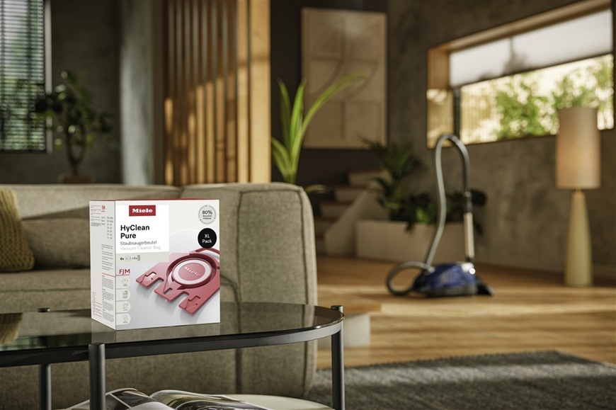 Balenie s vreckami do vysávača Miele HyClean Pure FJM sú položené na stole v modernej domácnosti.