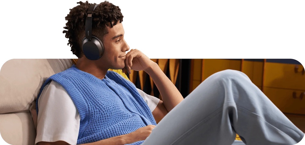 Slúchadlá Xiaomi REDMI Headphones Neo Obsidian biela Muž sediaci na gauči si užíva audio zo slúchadiel Xiaomi REDMI Headphones Neo s pohodlnou konštrukciou