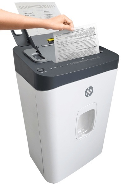 Skartovač HP OneShred Auto 200CC biely Osoba vkladá dokument do skartovačky.