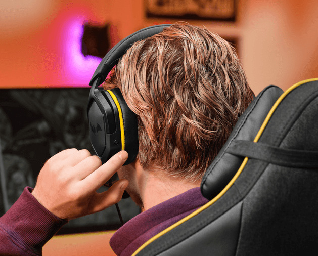 Headset Trust GXT 492BM Carus Batman čierny Muž so slúchadlami Trust GXT 492BM Carus Batman s ovládaním na náušníku