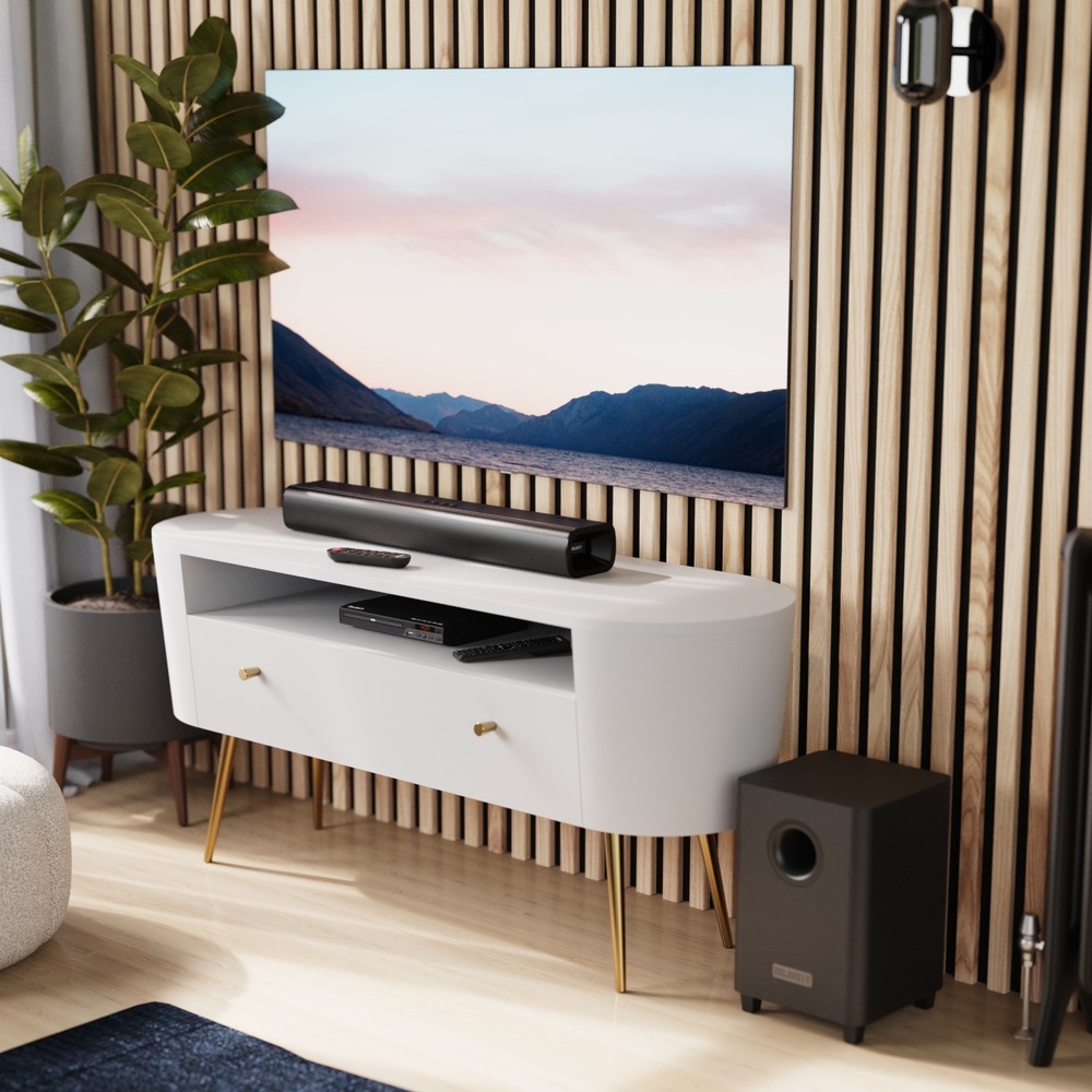 Soundbar Majority Naga 60 Plus pod televízorom a bezdrôtový subwoofer vedľa stolíka.