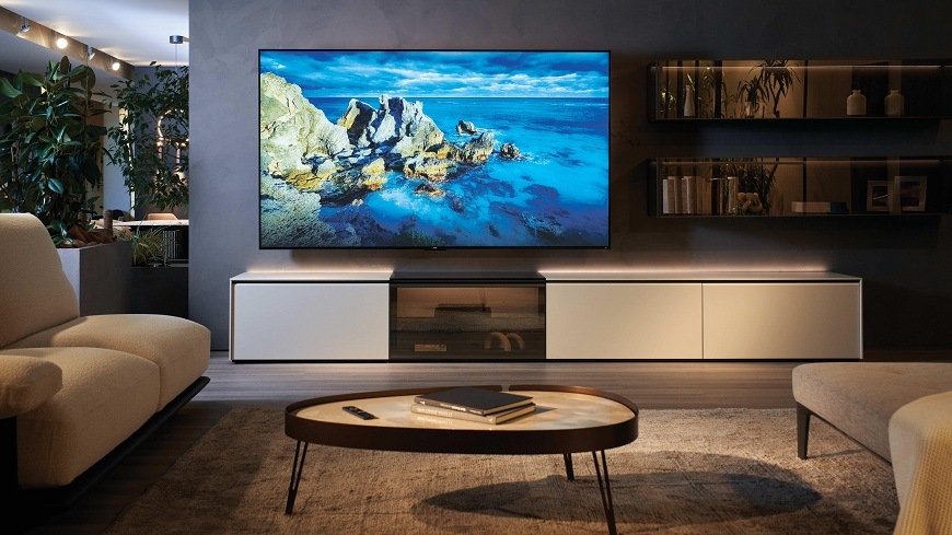 Televízia Haier H100S90FUX v obývačke s obrazom prírodnej krajiny