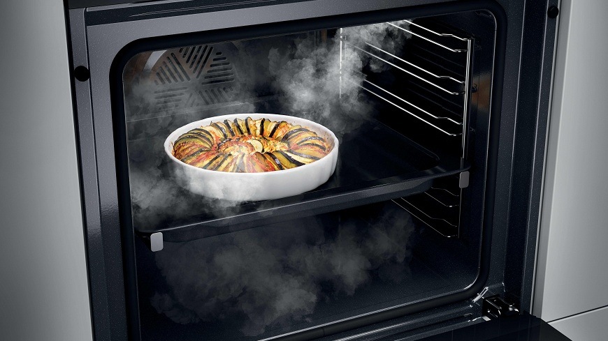 Rúra Haier H6 ID2P3B4VYTB čierna/sklo obsah otvorenej rúry Haier H6 ID2P3B4VYTB, vo vnútri sa vyskytuje para a na pekáčiku je ratatouille