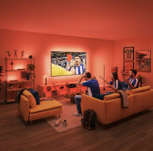 LED pásik Philips Smart LED HDMI 2.1 Sync box kit 75"-85" EU čierny Traja fanúšikovia sledujú futbal na televízore s červeným podsvietením zladeným s obrazom