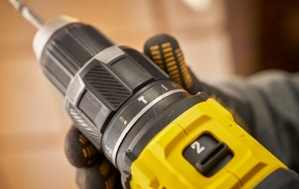 Aku vŕtačka Stanley FatMax SFMCD716B-XJ (bez baterie) Detail prepínača rýchlostí aku vŕtačky Stanley FatMax v rukavici chránenej ruke.