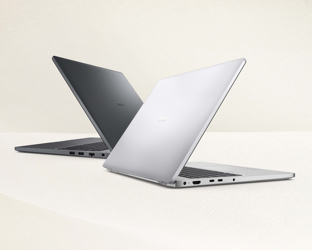 Notebook Dell Pro 16 Plus strieborný Dva elegantné notebooky s čiastočne otvorenými vekami, jeden strieborný a jeden čierny, sú umiestnené diagonálne na svetlom povrchu, čo zdôrazňuje ich moderný design a eleganciu.