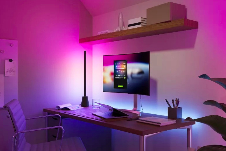 Stolná lampička Philips Hue Play Table EU Stolová lampička Philips Hue Play nasväcuje pracovný stôl a stenu za monitorom farebnými prechodmi
