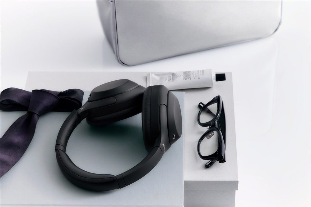 Slúchadlá Sony WH-1000XM4C čierna Slúchadlá Sony WH-1000XM4C položené na nábytku vedľa obuvi