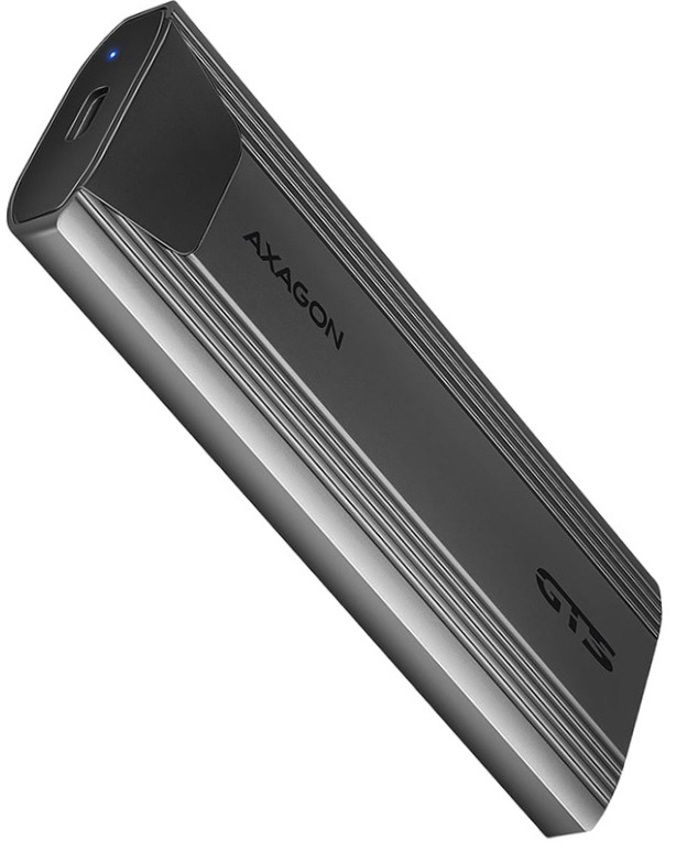 Na obrázku je šedý externý box AXAGON THIN pre M.2 SSD zachytený šikmo spredu. Má úzky, podlhovastý tvar so zaoblenými hranami a elegantné kovové telo s jemným pozdĺžnym rebrovaním po stranách. Na čele je USB-C konektor a malá modrá kontrolka, na hornej strane nápis AXAGON a označenie GTS. Zariadenie pôsobí kompaktne, moderne a technicky.