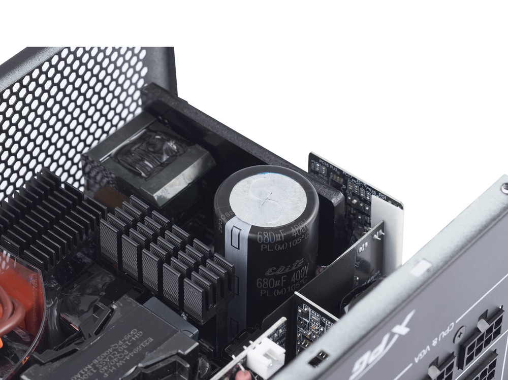 Zdroj ADATA XPG Core Reactor II VE 650W Gold Fotografie zdroja ADATA XPG CORE REACTOR II zachytáva časť vnútrajška zdroja s kondenzátorom a ďalšími prvkami.