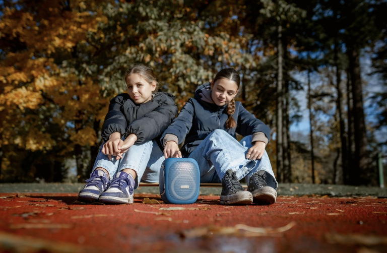 Prenosný reproduktor Concept SoundJoy BR5037 modrý Dve dievčatá počúvajú modrý reproduktor Concept SoundJoy BR5037 pri vonkajšom odpočinku