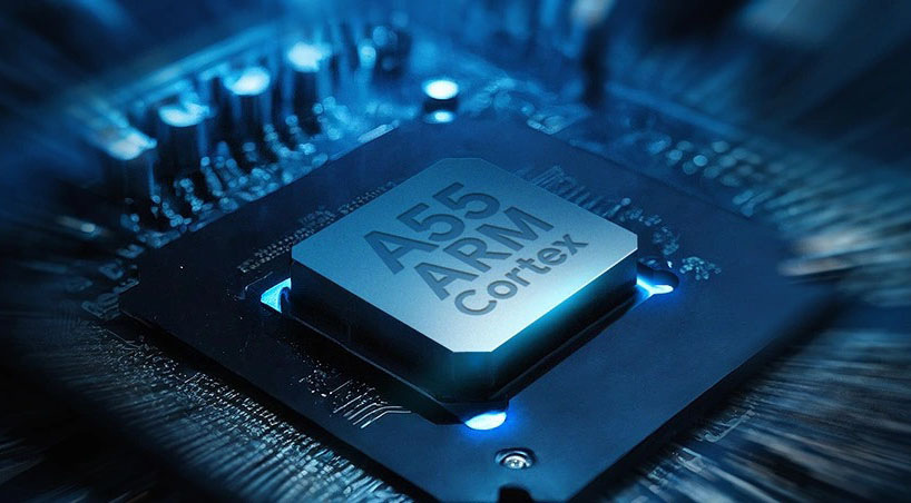 Detailný záber čipu ARM Cortex A55 na základnej doske televízora, podsvietený chladným modrým svetlom s rozmazanými okrajmi ilustrujúcimi vysoký výpočtový výkon.